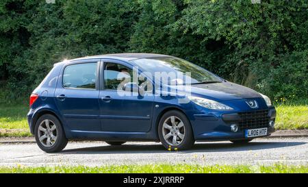 Milton Keynes, Großbritannien - 18. Juli 2024: 2006 blaues Peugeot 307 Auto fährt auf einer britischen Landstraße Stockfoto