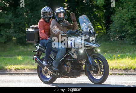 Milton Keynes, Großbritannien - 18. Juli 2024: Mann und Sozius auf einem Suzuki DL 1050 rc m2 Motorrad auf einer britischen Landstraße Stockfoto