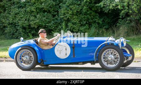 Milton Keynes, Großbritannien - 18. Juli 2024: 1935 blauer Riley britischer Oldtimer, der auf einer britischen Landstraße fährt Stockfoto