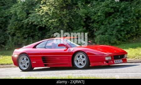 Milton Keynes, Großbritannien - 18. Juli 2024: 1994 roter Ferrari 348 Auto fährt auf einer britischen Landstraße Stockfoto