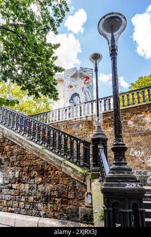 Treppe der Avenue Rachel, in der Nähe des Eingangs des Friedhofs Montmartre, mit typischer Pariser Straßenlaterne und Straßenkunst, Montmartre, Paris, Frankreich Stockfoto