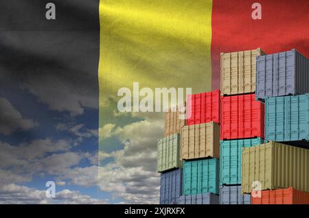 Belgische Flagge und großer Stapel von Frachtcontainern in Docks mit Himmelshintergrund aus nächster Nähe Stockfoto