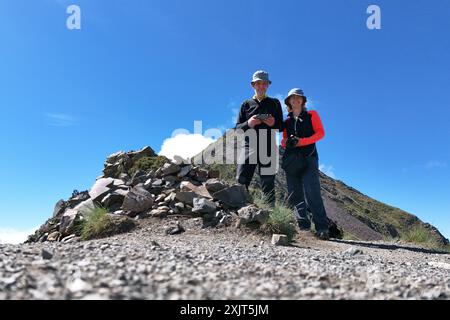 Ein älteres Paar wandert in den Bergen der Pyrenäen und bedient eine Drohne mit einem Joystick Stockfoto