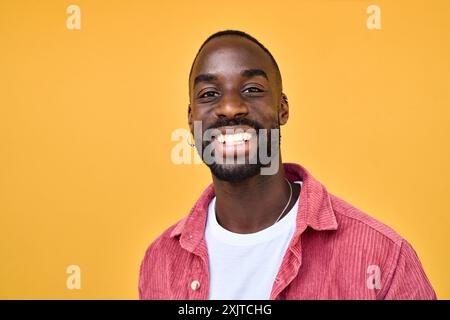 Glücklicher, fröhlicher, cooler Gen z Schwarzer Hipster-Typ, der an der gelben Wand steht. Hochformat. Stockfoto