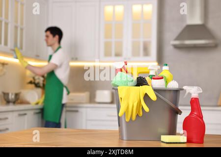Professioneller Hausmeister, der in der Küche arbeitet, konzentriert sich auf Eimer mit Zubehör. Reinigungsservice Stockfoto