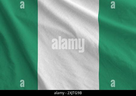 Nigeria-Flagge auf gefaltetem, gewelltem Stoff aus altem Tuch in Nahaufnahme dargestellt Stockfoto