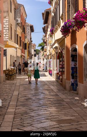 Farbenfrohe Geschäfte und Touristen in einer engen Kopfsteinpflasterstraße in der Altstadt von Porec, der istrischen Küste, Kroatien, Europa Stockfoto