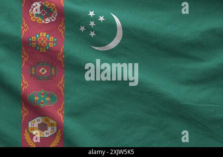 Turkmenistan-Flagge auf gefaltetem, gewelltem Stoff aus altem Tuch in Nahaufnahme dargestellt Stockfoto
