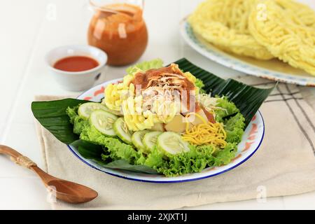 Nahaufnahme Rujak Juhi Asinan Jakarta. Traditioneller indonesischer Salat mit gelben Nudeln, Gemüse und gegrillten Tintenfisch-Crackern mit Erdnussdressing. Stockfoto