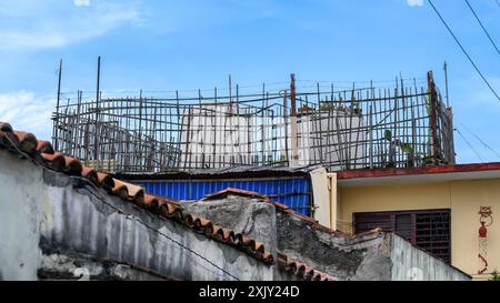Ein rustikaler Zaun, der zwei Wasserspeicher auf dem Dach schützt, Santa Clara, Villa Clara, Kuba, 2024 Stockfoto