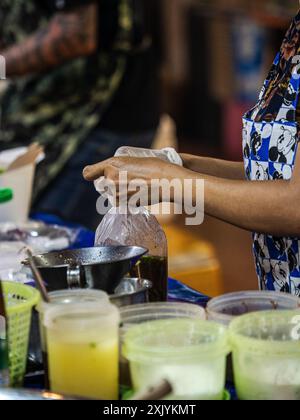 Straßenlieferant füllt Bestellung auf dem Nachtmarkt aus Stockfoto