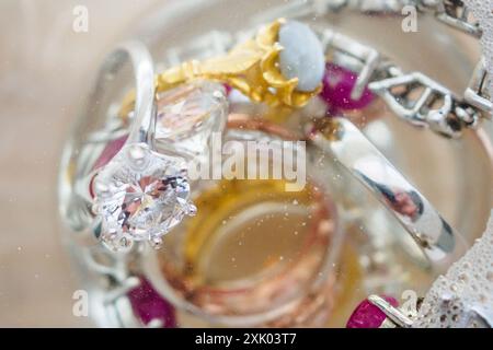 Reinigung Vintage Schmuck Diamant Ring und Armband in Glas auf Holztischhintergrund Stockfoto