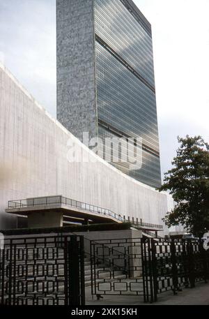 New York, USA. August 1959: Blick auf das Hauptquartier der Vereinten Nationen (UN) im Viertel Turtle Bay in Midtown Manhattan in New York City. Der Komplex wurde 1952 fertiggestellt und von einem Architekturausschuss unter der Leitung von Wallace Harrison entworfen und vom Architekturbüro Harrison & Abramovitz errichtet. Vor dem Gebäude befindet sich der ursprüngliche Zaunzaun und die Tore, die heute nicht mehr vorhanden sind. Stockfoto