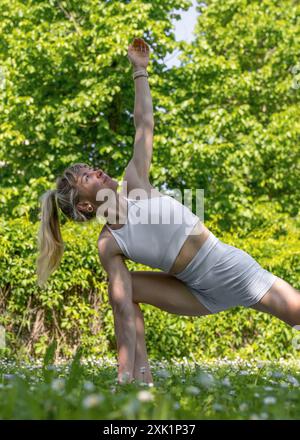 Ein junges, athletisches Mädchen dehnt sich aus, Yoga an der frischen Luft. Schönheit und Gesundheit. Aktiver Lebensstil. Körperliche Bewegung. Stockfoto