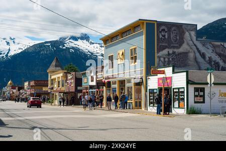 Blick auf den Broadway mit seinen Vintage-Geschäften und Touristenattraktionen vor der Kulisse schneebedeckter Berge. Stockfoto