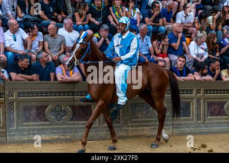 Jockeys in ihren Contrada-Farben machen sich auf den Weg zur Startlinie für das Palio-Rennen. Das Rennen dauert weniger als 90 Sekunden in Siena, Toskana, Italien. Stockfoto