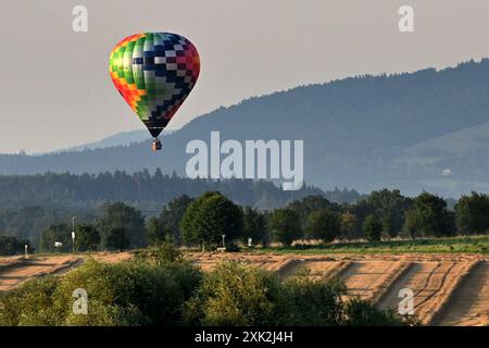 Libosovice, Tschechische Republik. Juli 2024. Ein Heißluftballon gleitet an einer Landschaft vorbei, während er sich auf die Landung bei Sonnenaufgang im Böhmischen Paradies bei Libosovice in Tschechien vorbereitet. (Kreditbild: © Slavek Ruta/ZUMA Press Wire) NUR REDAKTIONELLE VERWENDUNG! Nicht für kommerzielle ZWECKE! Stockfoto