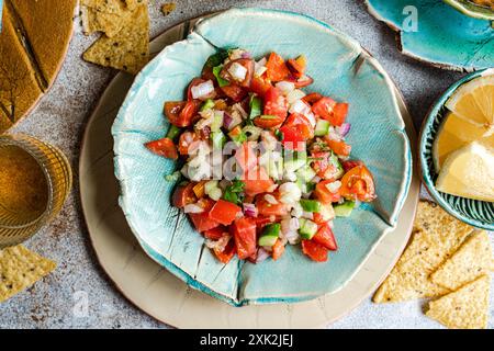 Blick von oben auf Pico de gallo, eine klassische mexikanische Salsa mit frischen Tomaten, Zwiebeln, Koriander, grüner Paprika, Avocado, und ein Spritzer Zitronensaft Stockfoto