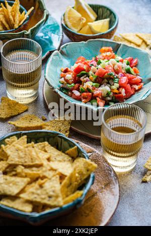 Lebendiges Pico de gallo, eine klassische mexikanische Salsa mit Tomaten, Zwiebeln, Koriander und einem Spritzer Zitronensaft, begleitet von goldenem Maischi Stockfoto