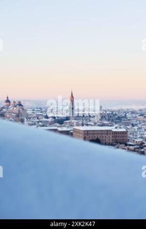 Ein ruhiger Wintermorgen in Toledo, Spanien, wenn das erste Licht des Sonnenaufgangs die schneebedeckte Stadtlandschaft beleuchtet und die markante Spitze des G zeigt Stockfoto