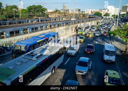 In Rio de Janeiro stehen einige Fahrzeugtypen und öffentliche Verkehrsmittel zur Verfügung (von rechts nach links) - Taxi, Pendler, Busse, Zug auf einem erhöhten Teil der U-Bahn-Linie 2 von Rio de Janeiro und Vorortzug im Hintergrund. Rei Pele Avenue, Stadtviertel Sao Cristovao, nördliche Zone der Stadt. Stockfoto