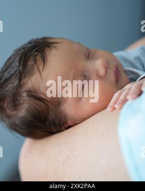 Der Kopf des Babys in den Händen der Mutter. Mom hält einen neugeborenen Jungen, das Baby schläft süß. Säuglingsgesundheit und -Entwicklung. Die Geburt eines Kindes und die Liebe von p Stockfoto