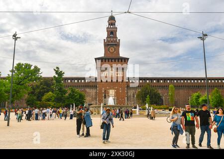 Touristen vor der mittelalterlichen Festung Castello Sforzesco auf der Piazza Castello, mit dem Brunnen und dem Filarete-Turm im Frühjahr, Mailand, Italien Stockfoto