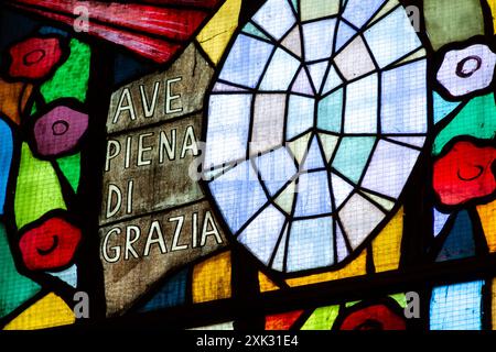 Buntglas mit den Worten: "Ave piena di grazia" [Heil, voller Anmut]. Santa Maria del Carmine in Pavia, Italien. Stockfoto