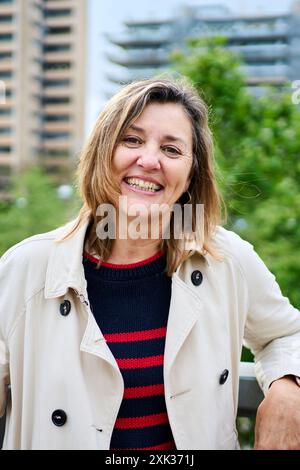 Porträt einer fröhlichen Reifen blonden kaukasischen Frau, die glücklich steht und draußen auf Geländer gelehnt ist. Stockfoto