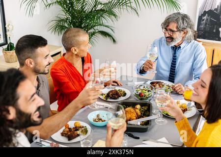 Glückliche, generationsübergreifende Familie, die zu Hause ein Mittagessen genießt Stockfoto