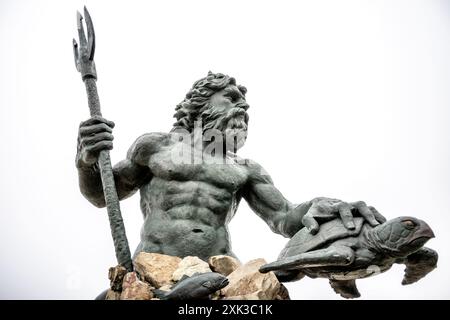 Neptun-Statue Virginia Beach Virginia | VIRGINIA BEACH, VA, Vereinigte Staaten — Eine auffällige Statue des Neptun bewacht den Strandpromenade von Virginia Beach und symbolisiert die tiefe Verbindung der Stadt zum Meer und zum maritimen Erbe. Enthüllt im Jahr 2005 und geschaffen vom in Richmond ansässigen Bildhauer Paul DiPasquale, überblickt Neptuns imposante Präsenz mit einer Höhe von 34 Fuß den Atlantischen Ozean und dient als Wächter der Küste der Stadt. Stockfoto