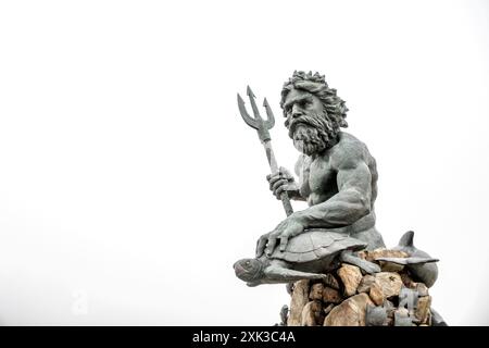Neptun-Statue Virginia Beach Virginia | VIRGINIA BEACH, VA, Vereinigte Staaten — Eine auffällige Statue des Neptun bewacht den Strandpromenade von Virginia Beach und symbolisiert die tiefe Verbindung der Stadt zum Meer und zum maritimen Erbe. Enthüllt im Jahr 2005 und geschaffen vom in Richmond ansässigen Bildhauer Paul DiPasquale, überblickt Neptuns imposante Präsenz mit einer Höhe von 34 Fuß den Atlantischen Ozean und dient als Wächter der Küste der Stadt. Stockfoto