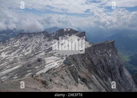 Symbolbild Wanderer, felsiges Gelände, Berglandschaft, steiler Aufstieg, Rucksack, schneebedeckte Flecken, Wanderroute, Gebirgspfad, Outdoor-Aktivität, Bergwandern, Menschen in der Ferne, karge Landschaft, steiniger Pfad, hochgelegene Region, Geröllfeld, Panorama, Berggipfel, Wolkenhimmel, Bergblick, Alpines Klima, kühle Temperaturen, dünne Luft, Klimawandel, schmelzende Gletscher, veränderte Wetterbedingungen, Zugspitze. *** Symbolischer Imagewanderer, felsiges Gelände, Berglandschaft, steiler Aufstieg, Rucksack, schneebedeckte Flecken, Wanderroute, Bergweg, Outdoor-Aktivitäten, Bergwandern, peo Stockfoto