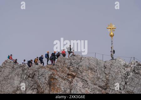 Symbolbild Wanderer, felsiges Gelände, Berglandschaft, steiler Aufstieg, Rucksack, schneebedeckte Flecken, Wanderroute, Gebirgspfad, Outdoor-Aktivität, Bergwandern, Menschen in der Ferne, karge Landschaft, steiniger Pfad, hochgelegene Region, Geröllfeld, Panorama, Berggipfel, Wolkenhimmel, Bergblick, Alpines Klima, kühle Temperaturen, dünne Luft, Klimawandel, schmelzende Gletscher, veränderte Wetterbedingungen, Zugspitze, Alpen, Seilbahn, Schmelzwassersee, Gipfelkreuz, Wandergruppe, Selfies, Handys, Schlange für Selfie *** Symbolbildwanderer, felsiges Gelände, Berglandschaft, steiler Aufstieg, b Stockfoto