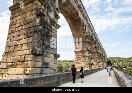 Pont du Gard römischer Aquädukt Vers-Pont-du-Gard Frankreich // VERS-PONT-DU-GARD, Frankreich – der majestätische Pont du Gard, ein altes römisches Aquädukt und UNESCO-Weltkulturerbe, erstreckt sich über den ruhigen Fluss Gardon in Südfrankreich. Diese bemerkenswerte dreistöckige Brücke zeigt den Einfallsreichtum römischer Technik vor dem Hintergrund der malerischen mediterranen Landschaft. Stockfoto
