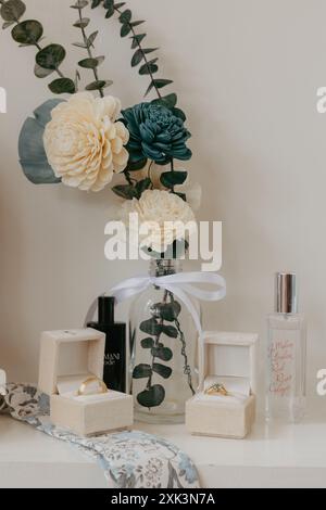 Ein elegantes Arrangement aus Blumen, Parfümflaschen und Schmuckkästen mit Ringen auf weißer Oberfläche Stockfoto