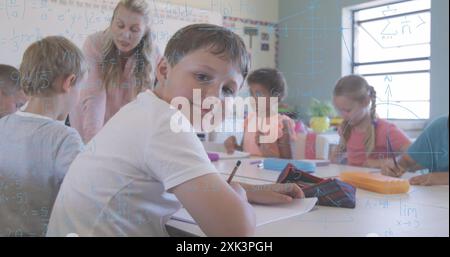 Das Bild von Mathe-Formeln über kaukasische Schüler, die in der Schule lernen Stockfoto