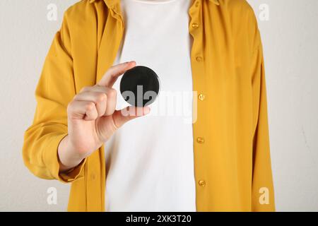 Frau mit leerem schwarzen Knopfabzeichen auf hellem Hintergrund, Nahaufnahme Stockfoto