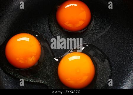 Rohe Wachteleier in schwarzer Pfanne als Hintergrund, Nahaufnahme Stockfoto
