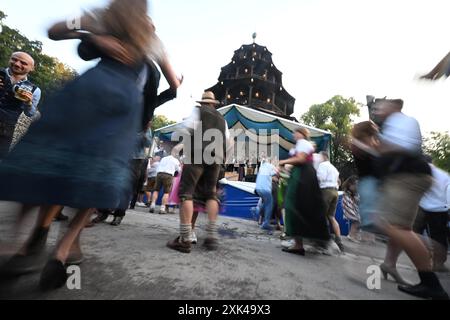 München, Deutschland. Juli 2024. Gäste tanzen im Kocherlball am Chinesischen Turm. Das traditionelle Open-Air-Volkstanz-Festival, das gewöhnlich bei Sonnenaufgang im Englischen Garten an einem Sommertag stattfindet, geht auf das 19. Jahrhundert zurück. Quelle: Felix Hörhager/dpa/Alamy Live News Stockfoto