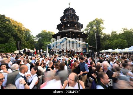 München, Deutschland. Juli 2024. Gäste tanzen im Kocherlball am Chinesischen Turm. Das traditionelle Open-Air-Volkstanz-Festival, das gewöhnlich bei Sonnenaufgang im Englischen Garten an einem Sommertag stattfindet, geht auf das 19. Jahrhundert zurück. Quelle: Felix Hörhager/dpa/Alamy Live News Stockfoto