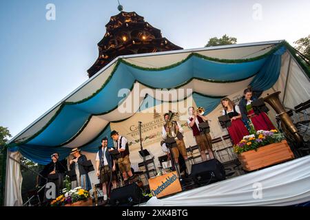 Kocherlball am Chinesischen Turm, Musikkapelle Quetschnblech beim Soundcheck um 5:15 Uhr, München, 21. Juli 2024 Deutschland, München, 21. Juli 2024, Musikkapelle Quetschnblech beim Soundcheck um 5:15 Uhr, Musik und Tanzen starten erst um 6 Uhr, Englischer Garten, Besucher feiern und tanzen früh morgens zu bayerischer Musik, sitzen schon teilweise ab 4 Uhr früh im Biergarten, Tradition entstand im 19. Juli. Jahrhundert, als Hauspersonal, Dienstboten und KöchInnen in den frühen Morgenstunden vor Dienstbeginn feiern und getanzt haben, Tradition wurde ab 1989 wiederbelebt, traditionell am 3. Sonntag Stockfoto