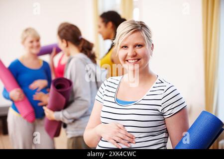 Frau, Schwangere und Workout mit einer Gruppe von Freunden, Lächeln oder Porträt für Schwangerschaftspilates. Yoga, Fitness oder Studio für Flexibilität und fröhliche Menschen Stockfoto