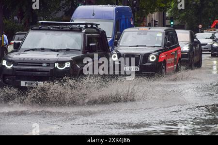 London, Großbritannien. Juli 2024. Autos plätschern durch eine wasserdurchflutete Euston Road, während starker Regen die Hauptstadt tränkt. Quelle: Vuk Valcic/Alamy Stockfoto