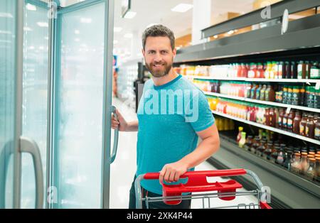 Kunde Kunde Kunde mit Einkäufen. Mann mit Einkaufswagen in einem Lebensmittelgeschäft. Stockfoto