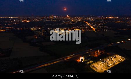 Vollmond der rote Vollmond zieht über die Frankfurter Bankenskyline hinweg. Wegen seiner rötlichen Färbung beim Aufgang wird der Vollmond im Monat Juli auch Erdbeermond oder Blutmond genannt. Luftbild mit einer Drohne Frankfurt am Main Hessen Deutschland *** Vollmond der rote Vollmond überquert Frankfurts Bankenskyline wegen seiner rötlichen Farbe bei Sonnenaufgang, der Vollmond im Juli ist auch als Erdbeermond oder Blutmond bekannt Luftaufnahme mit Drohne Frankfurt am Main Hessen Deutschland 2024-07-20 ffm vollmond 06 Stockfoto