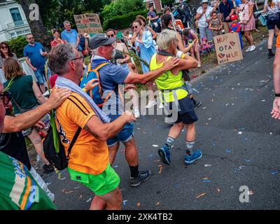 Nijmegen, Niederlande. Juli 2024. Die Teilnehmer werden beim Gehen beim Tanzen beobachtet. Die International Four Days Marches, das weltweit größte mehrtägige Wanderereignis, wurden aufgrund der am letzten Tag zu erwartenden sengenden Temperaturen um 10 km pro Distanz verkürzt. Zusätzliche Wasserversorgung und medizinische Unterstützung für die Teilnehmer wurden ebenfalls bereitgestellt. Quelle: SOPA Images Limited/Alamy Live News Stockfoto