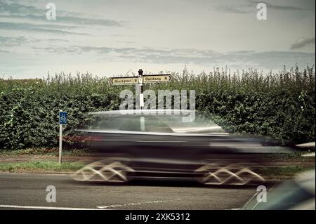 Verkehr auf der A585 zwischen Blackpool und Garstang mit den Fingerpfeilern der Stufe 2 am Grasrand Stockfoto