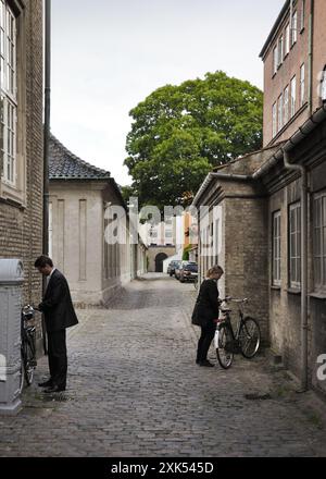 Seitenstraße in Kopenhagen. Die Leute parken ihre Fahrräder an den Wänden. Alte Backsteinhäuser im Hintergrund. Stockfoto