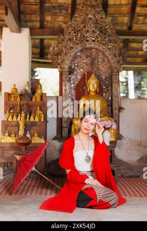 Nordthailändische Chiangmai lanna Leute in traditioneller Kleidung schöne Frauen alte Vintage Kleidung mit Papierschirm im wat Ton kwen. Stockfoto